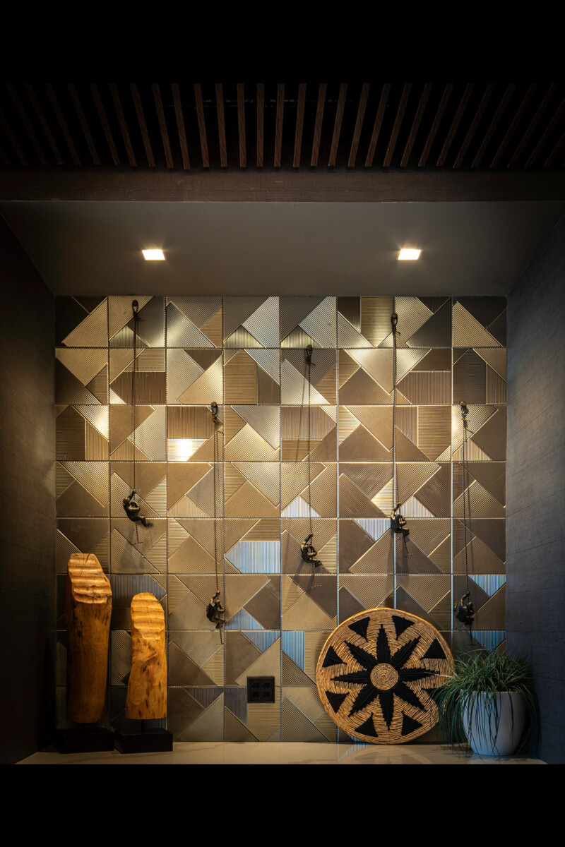 Geometric metal tile feature wall with carved wood accents