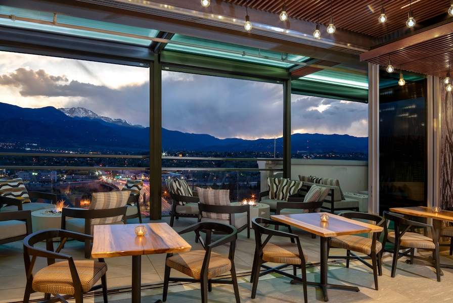Evening view from Ryze Skyline Lounge terrace with mountains and string lights