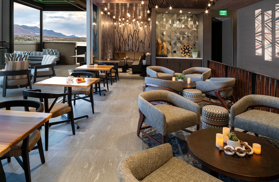 Open lounge linking bar, soft seating, and terrace with flexible event layout