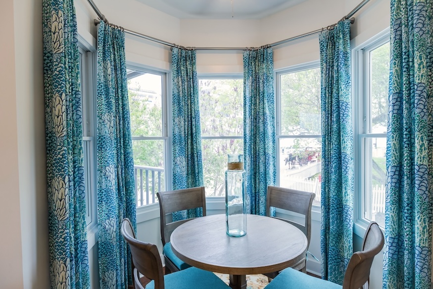 Bay window seating area with round table and chairs at Lake View Hotel.